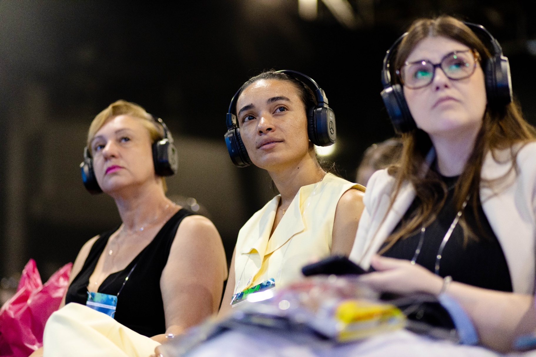 Visitantes emocionadas com fones durante palestra do Congresso