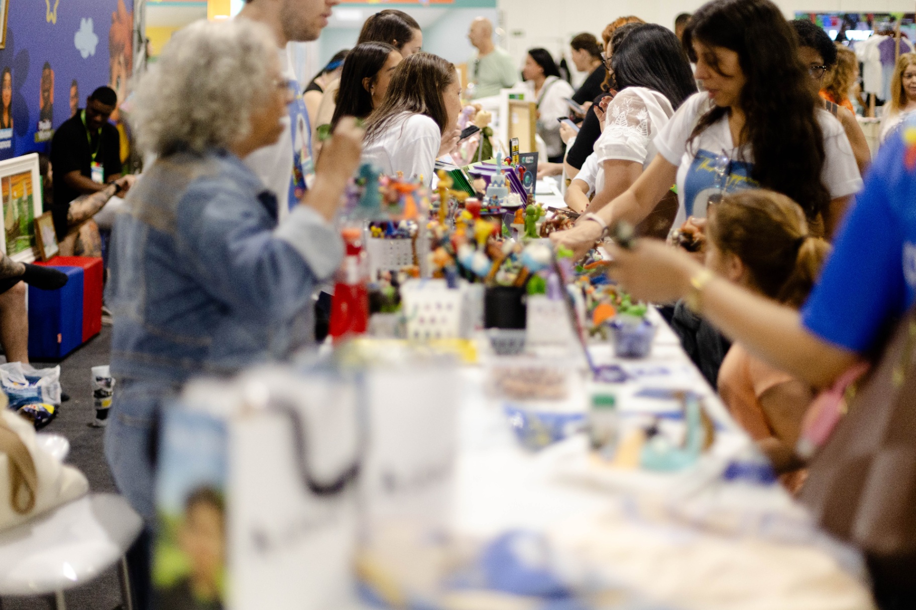 Visitantes interagindo com expositores de artesanato