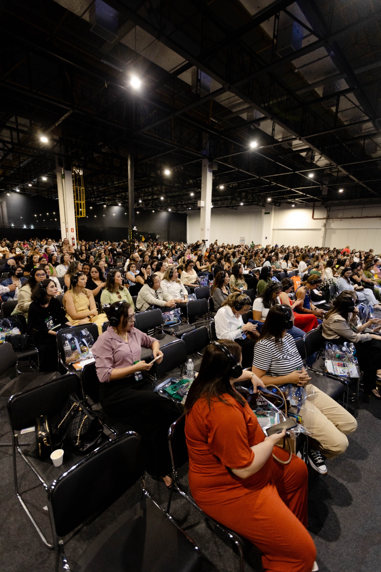Plateia lotada do Congresso ExpoTEA acompanhando palestra com fones